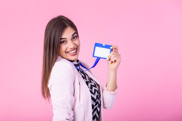 Photo young attractive businesswoman holds her badge and pointing it to camera isolated on background id template