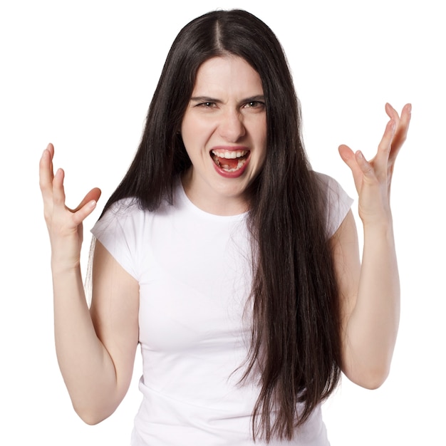 Young attractive caucasian black haired brunette woman in white t shirt, hands raised, anger woman concept idea