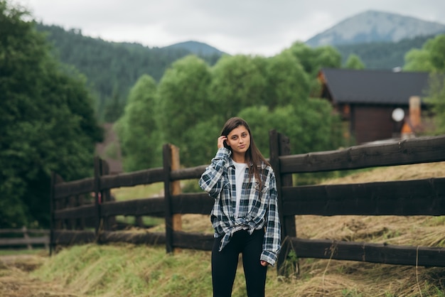 A young attractive Caucasian female sitting on a fence