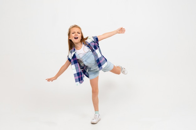 Young attractive charming caucasian girl jumping in casual clothes on a light blue studio background