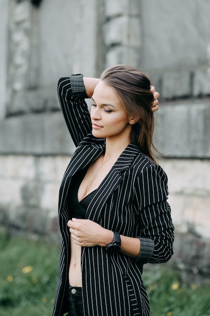 Young attractive cheerful woman walking in city.