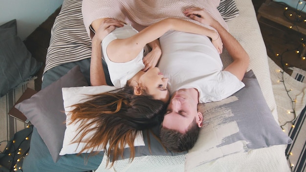 Young attractive couple cuddling and waking up together family relationships