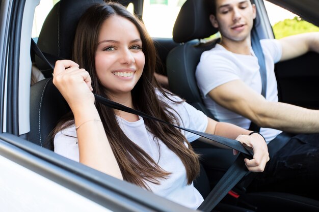 Young attractive couple riding in a car