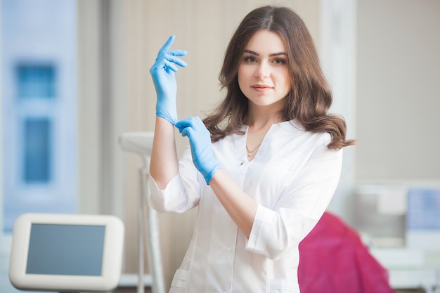 Giovane femmina attraente medico al chiuso. ritratto della donna che indossa uniforme medica nella clinica. medico con attrezzatura medica. cosmetologo nel suo salotto