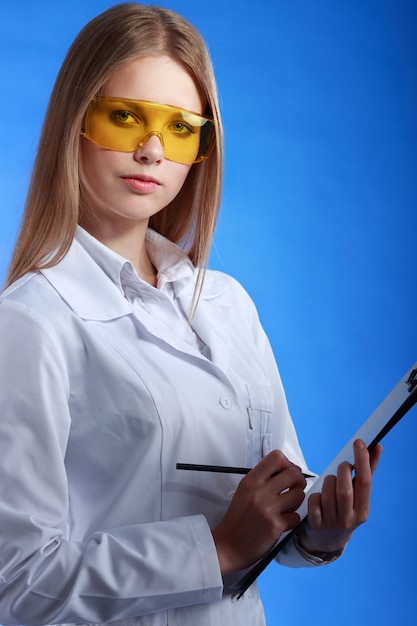 Young attractive doctor isolated over blue background