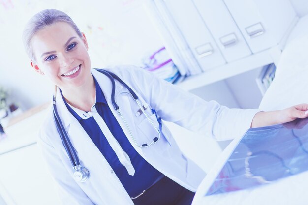 Young attractive female doctor looking at xray image