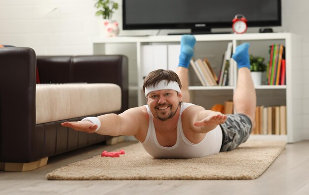 Young attractive fitness man lies on a fat mat with