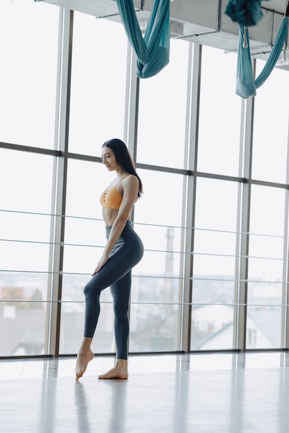 Young attractive girl doing fitness exercises with yoga on the floor