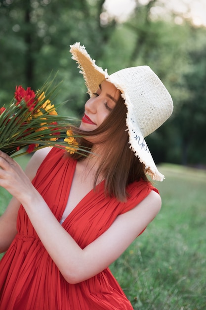 Young attractive girl holds a bouquet of summer wildflowers. 