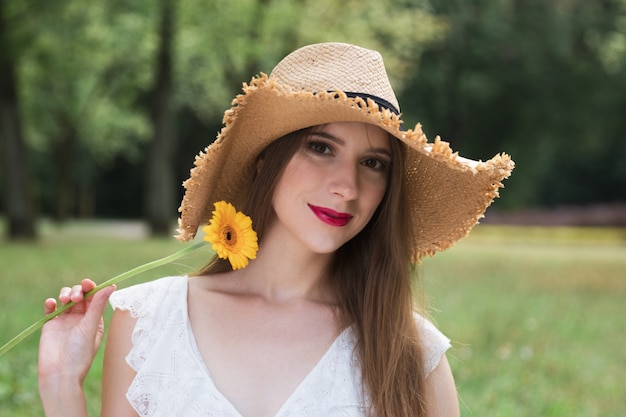 Young attractive girl holds a summer wildflower.