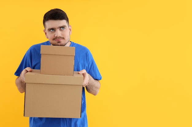 Photo young attractive guy with cardboard boxes in hands