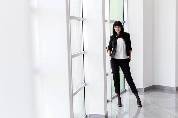 Young Attractive happy brunette woman dressed in a black business suit