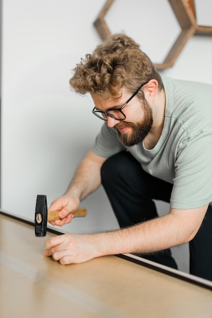 Photo young attractive man assembles furniture handwerker and interior objects concept