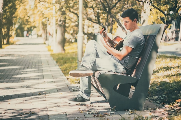 若い魅力的な男は、最後の晴れた日にライブ音楽を楽しんでいます秋の休日レトロなレンズを使用