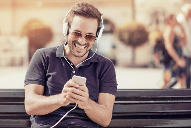 Young attractive man is smiling while wearing headphones