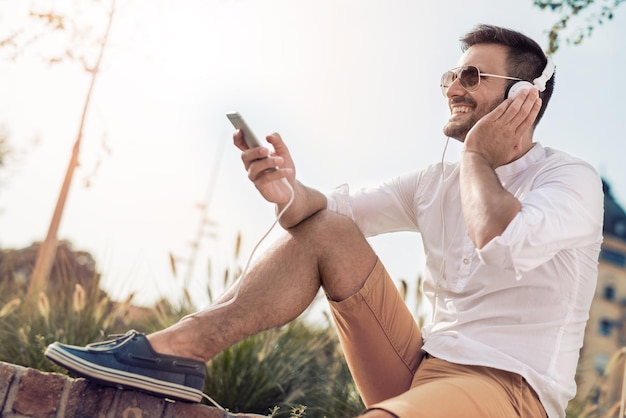 Young attractive man is smiling while wearing headphones