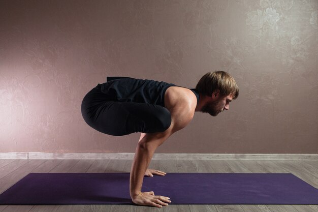 Young attractive man practicing yoga wearing sportswear