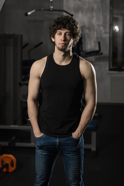 Young attractive man resting in gym after exercising