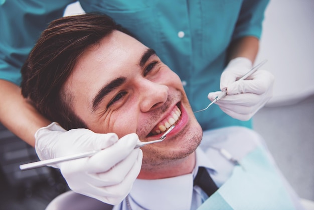 Young attractive man on a review of the doctor dentist Closeup