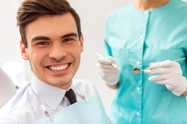 Young attractive man on a review of the doctor dentist Closeup