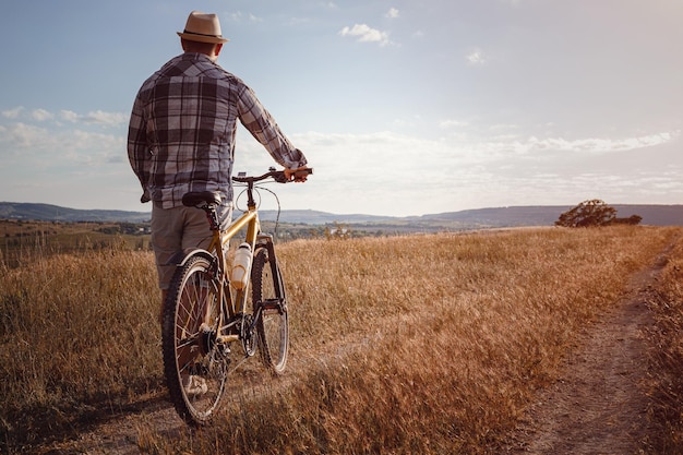 Young attractive man traveling on bicycle on summer vacation