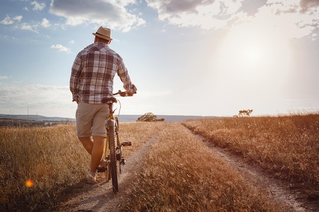 Young attractive man traveling on bicycle on summer vacation