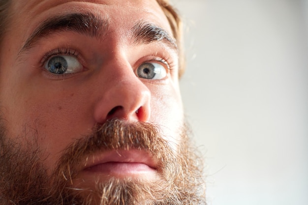 A young attractive man with blue eyes and a thick beard