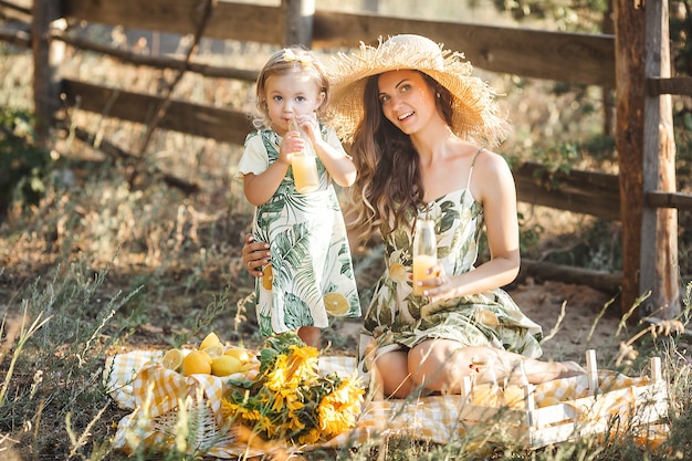 Young attractive mother and her little baby girl outdoors. Pretty family