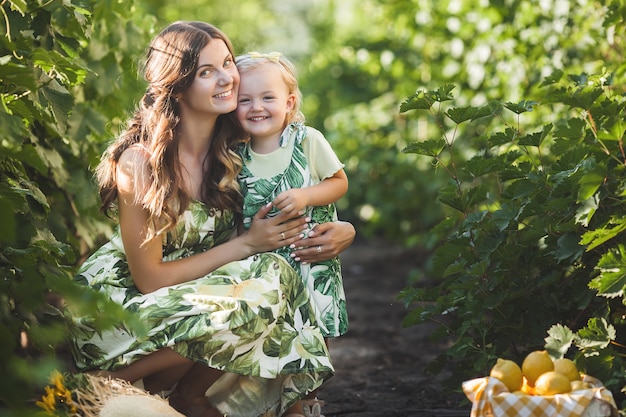 Young attractive mother and her little baby girl outdoors.