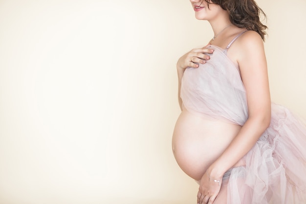 Молодая привлекательная беременная женщина дома. Закройте изображение ожидая самки.