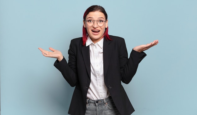 Young attractive red hair woman feeling happy, excited, surprised or shocked, smiling and astonished at something unbelievable