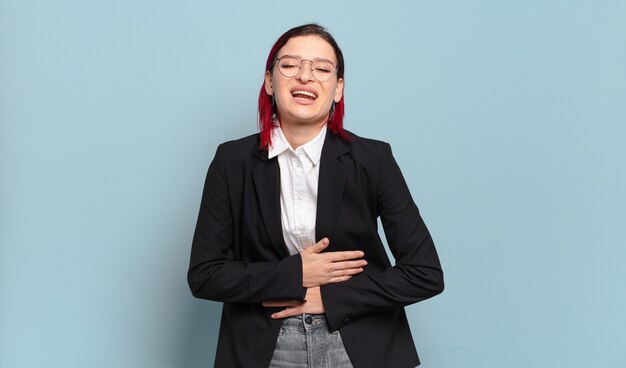 Young attractive red hair woman laughing out loud at some hilarious joke, feeling happy and cheerful, having fun