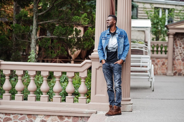 Young attractive serious african american man model Modern handsome guy in jeans jacket standing on urban city street