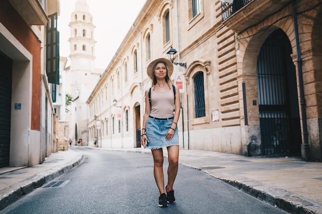Молодая привлекательная улыбающаяся девушка-турист изучает новый город летом