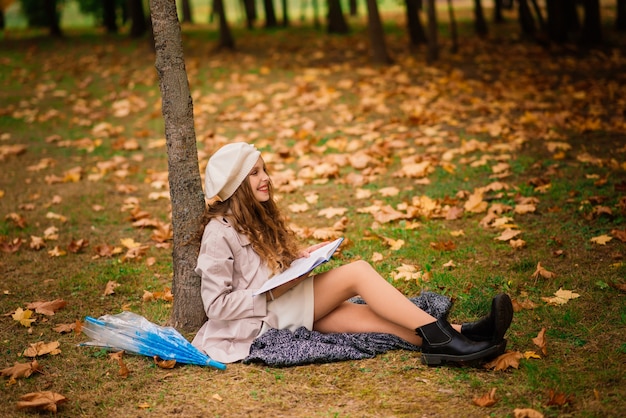 Young attractive smiling girl under umbrella in autumn forest