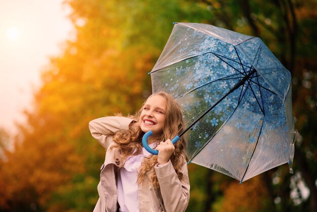 young attractive smiling girl under umbrella in autumn forest