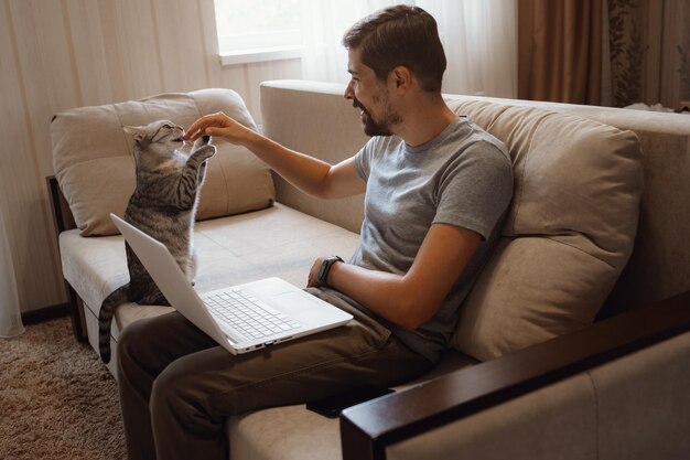 Young attractive smiling guy is browsing at his laptop