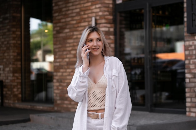 Young attractive smiling happily talking on a smartphone on a city street