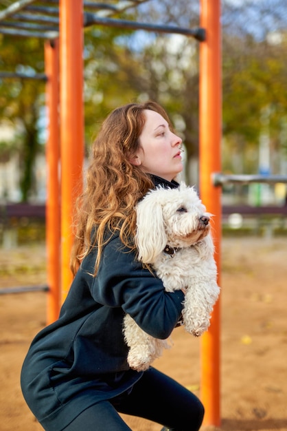 屋外で犬と一緒に運動をしている若い魅力的なスポーツ女性