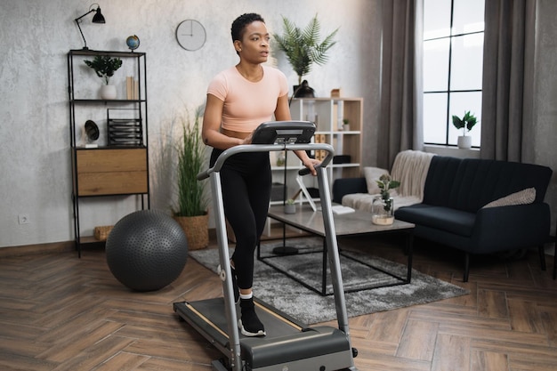 Young attractive sporty african american woman in sportswear having morning workout