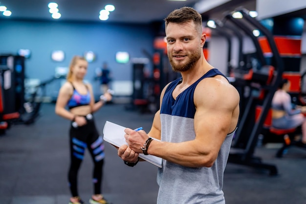 Young attractive sporty male instructor Handsome personal trainer working with his client