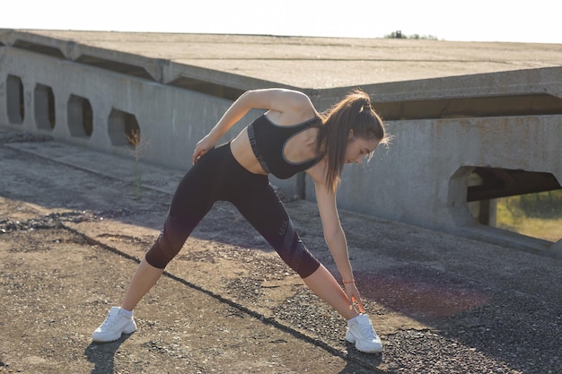 Young attractive woman doing exercise working out outdoors