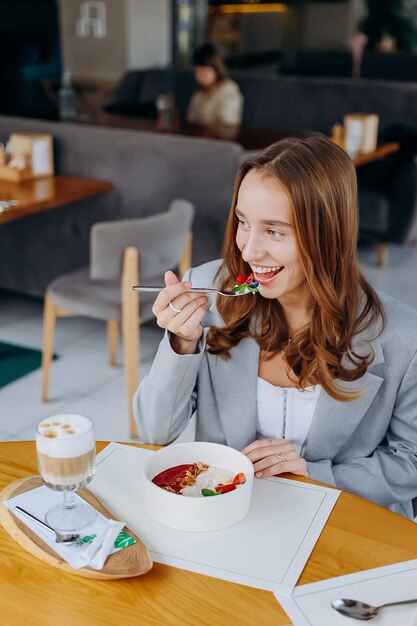 Photo young attractive woman enjoys tasty meal on cafe or restaurant background