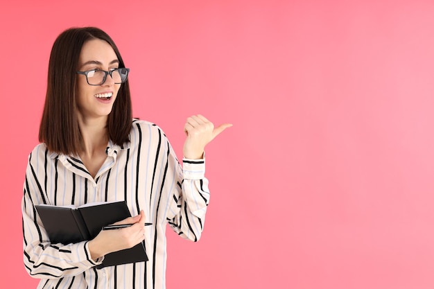 Young attractive woman in glasses on pink background