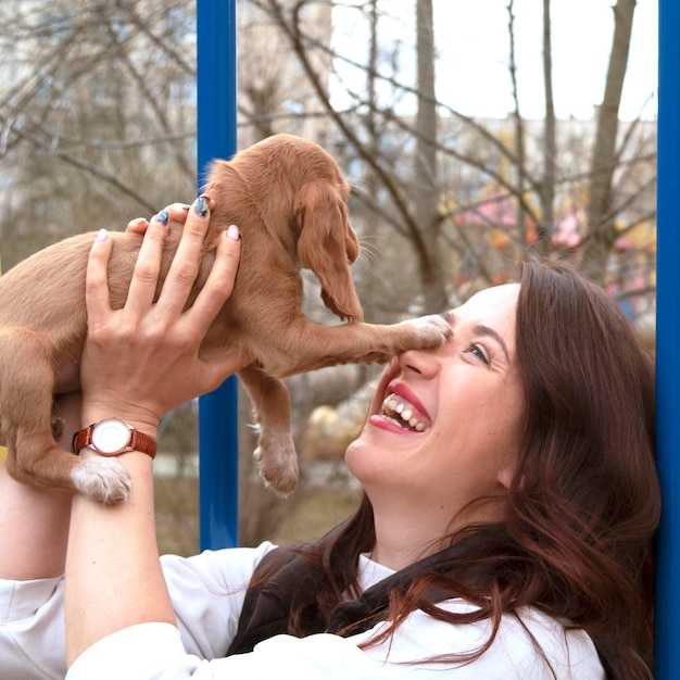 젊은 매력적인 여자는 귀여운 코커 스패니얼 강아지를 안아줍니다. 새로운 귀여운 가족 구성원입니다. 애완 동물 관리 및 애완 동물 개념