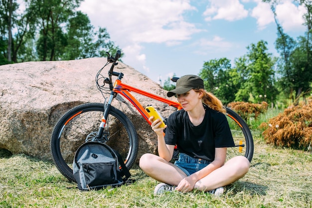 若い魅力的な女性は、自転車に乗った後休んでいるアクティブなライフ スタイル スポーツ