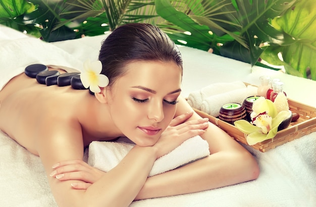 Young attractive woman is undergoing of stone therapy.