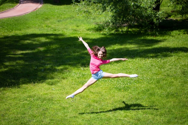 Young attractive woman jumping in the summer park