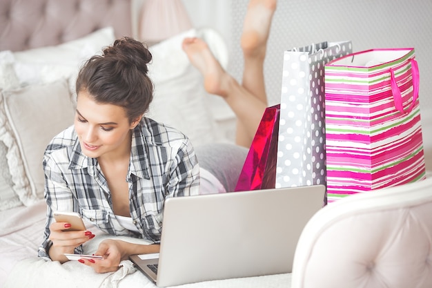 Foto giovane donna attraente che fa shopping online a casa