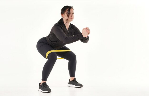 Молодая привлекательная женщина делает упражнения на растяжку йоги и гимнастики, изолированные на белом фоне
